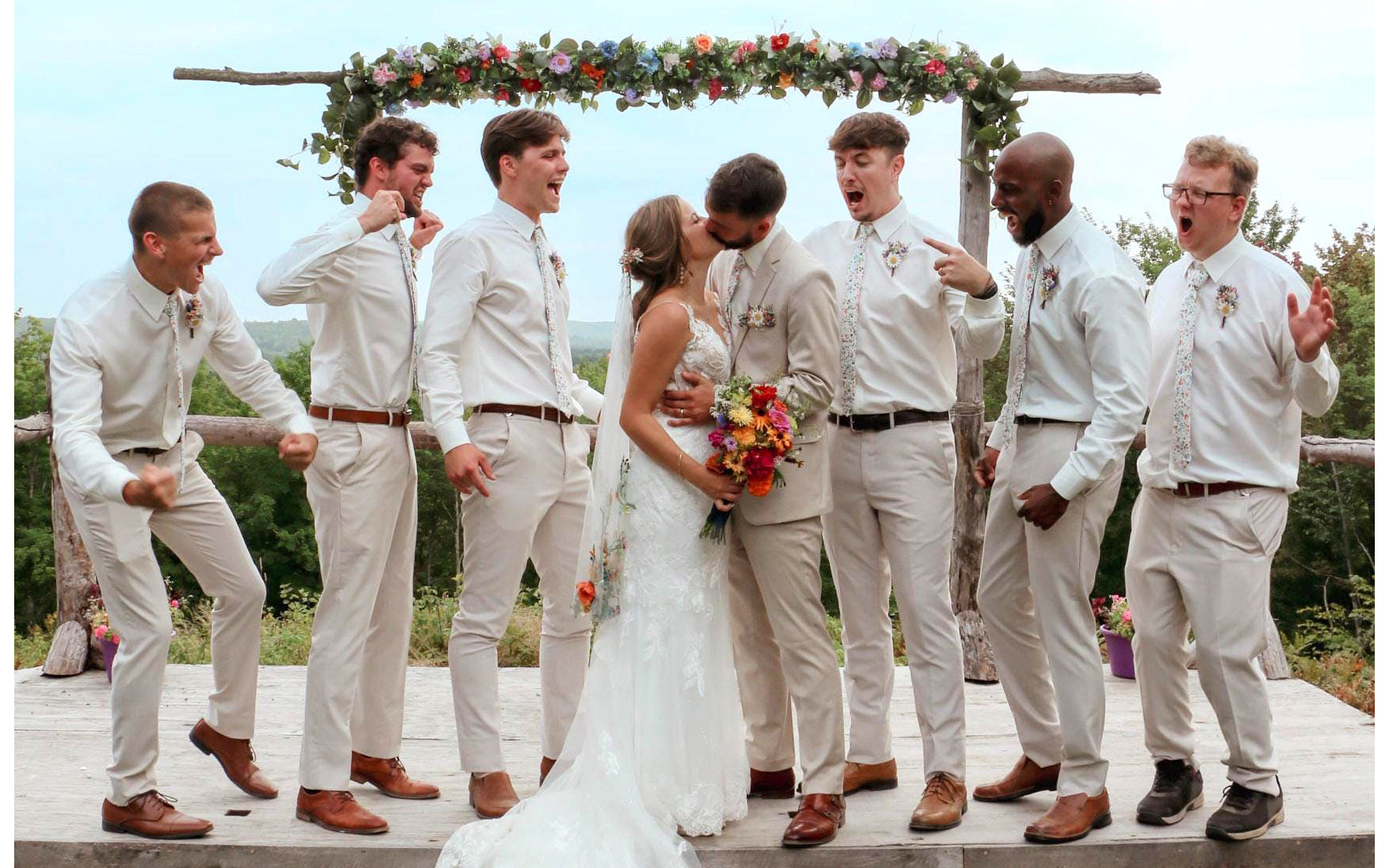 Wedding party celebrating with a bride and coordinated groomsmen in an outdoor ceremony